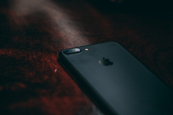 Un iPhone noir sur un coin de table.