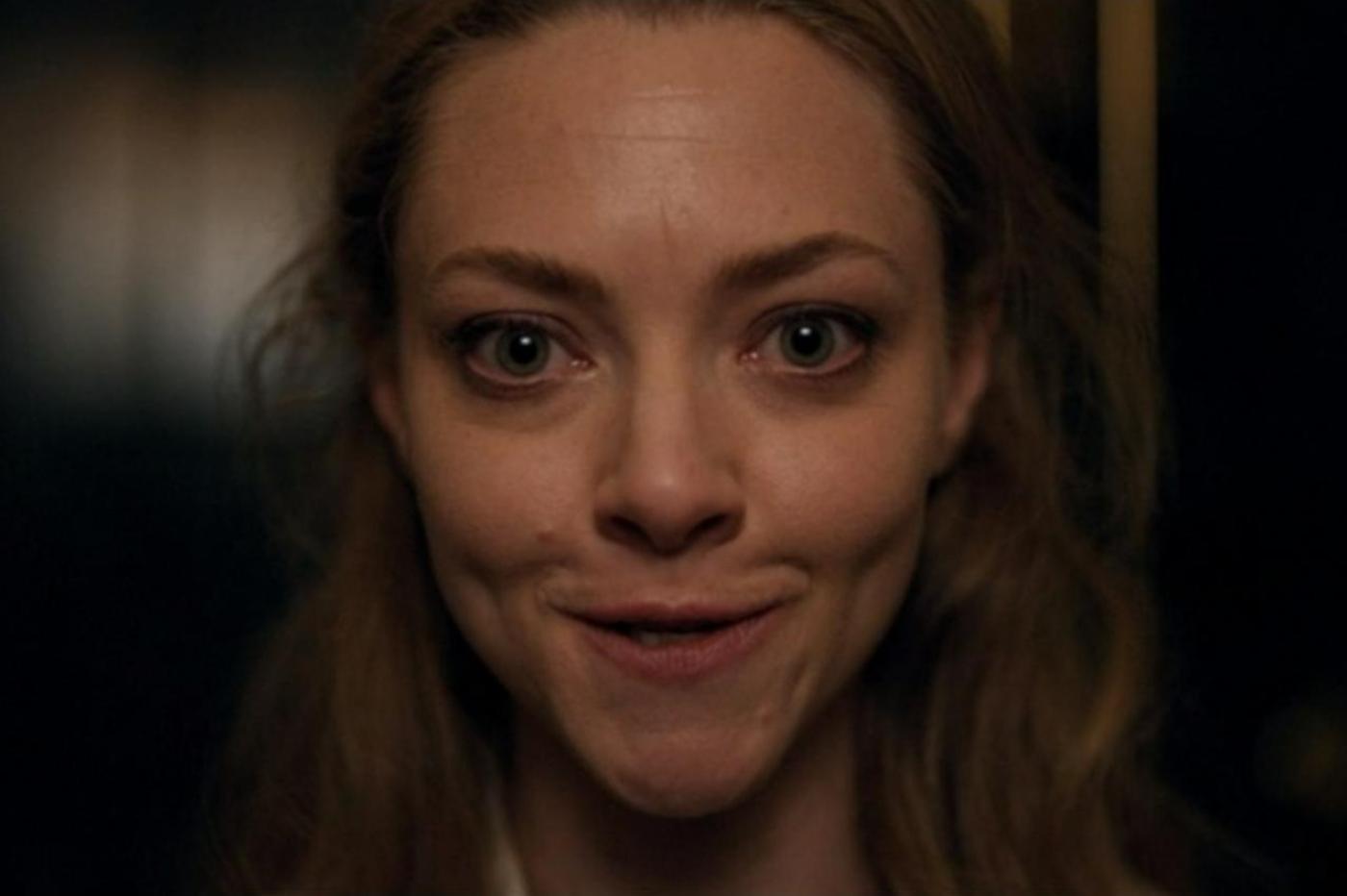 Capture d'écran de la série The Dropout montrant Elizabeth Holmes en train d'essayer de faire des expressions faciale devant un miroir. Son regard est terrifiant sur cette image.