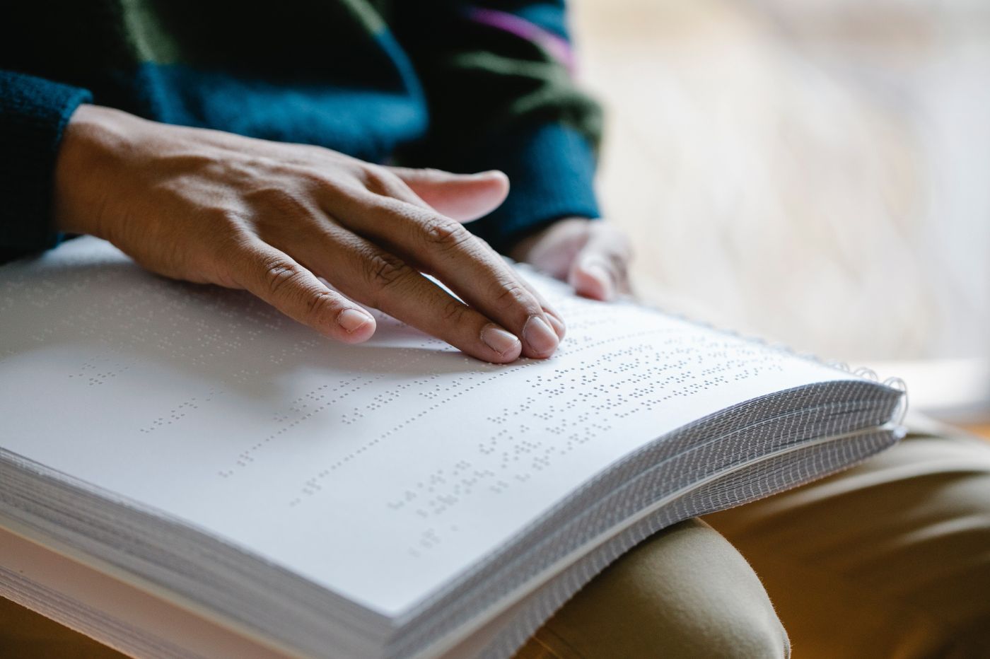 Une main glissant sur un livre en braille