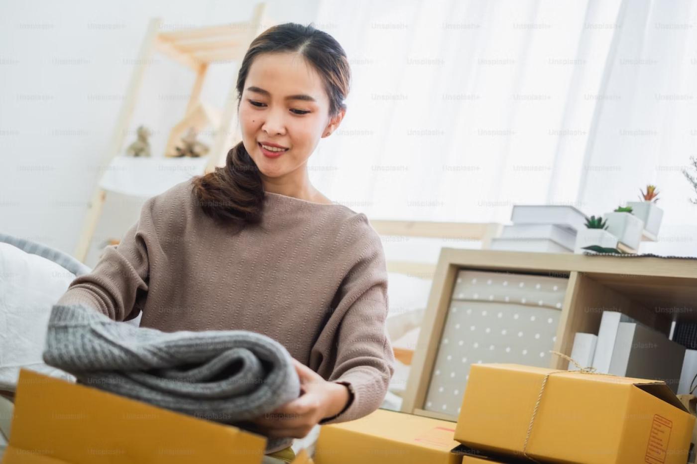 Femme avec carton et vêtements