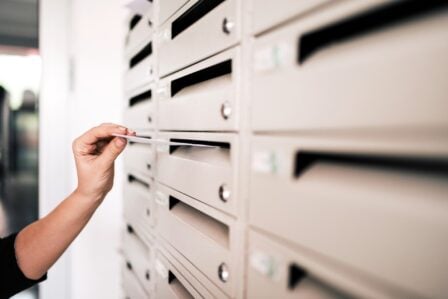 Un bout de papier blanc glissé sous une porte pour déverrouiller un accès sécurisé