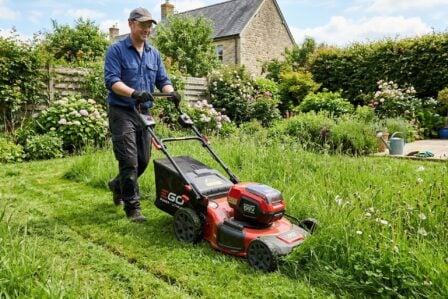 Tondeuse à gazon sur pelouse verte au printemps