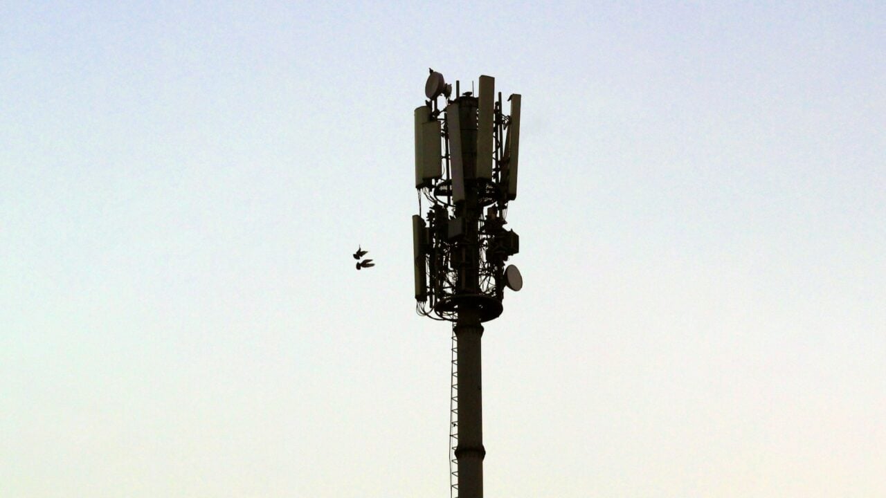 Technicien inspectant un système de communication d'urgence d'ascenseur relié au réseau 3G