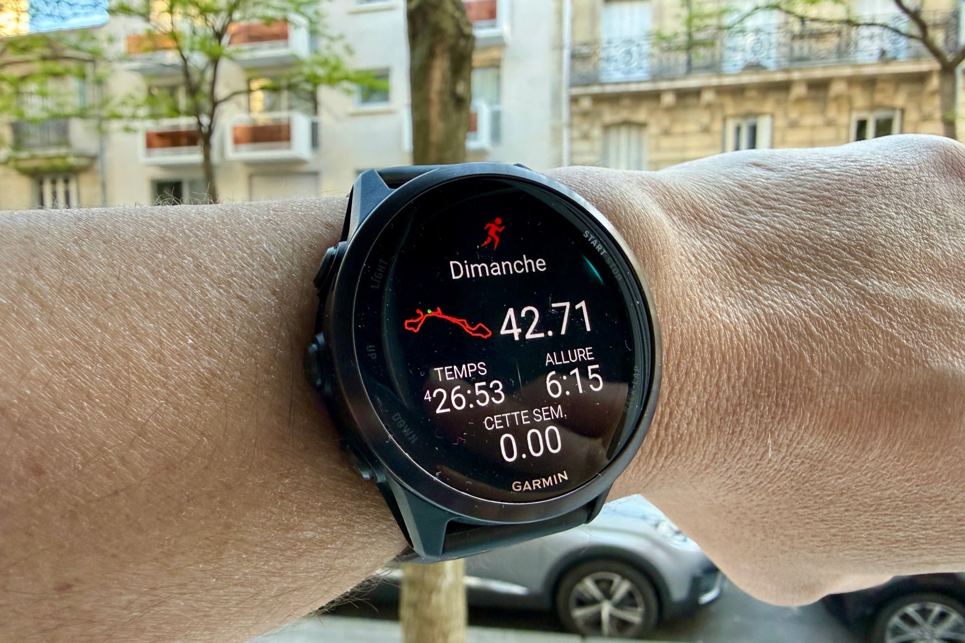 Garmin Forerunner 570 au poignet d'une coureuse lors du Marathon de Paris 2025 sur les Champs-Élysées