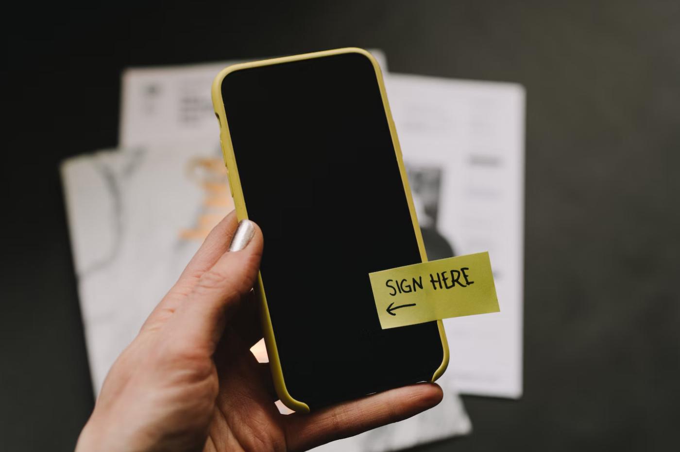 Un smartphone avec la mention "signez ici"